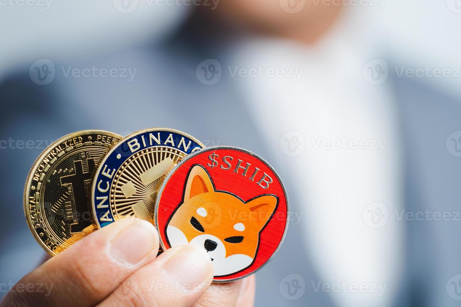 moneda dorada de bitcoin moneda shiba, grupo binance coin bnb incluido con criptomoneda en mano hombre de negocios con traje azul. archivar y poner y dar a mí. primer plano y concepto de fotografía macro. foto