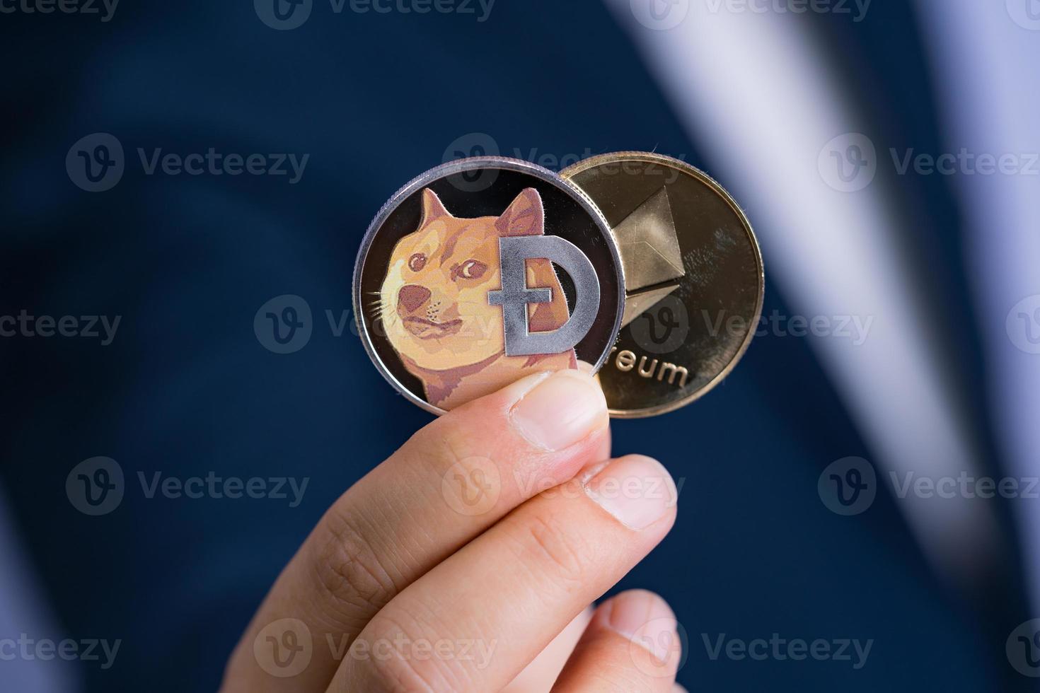 Golden Ethereum ETH Dogecoin DOGE group included with Cryptocurrency on hand business man wearing a blue suit. Filed and put and give to me. Close up and Macro photography concept. photo