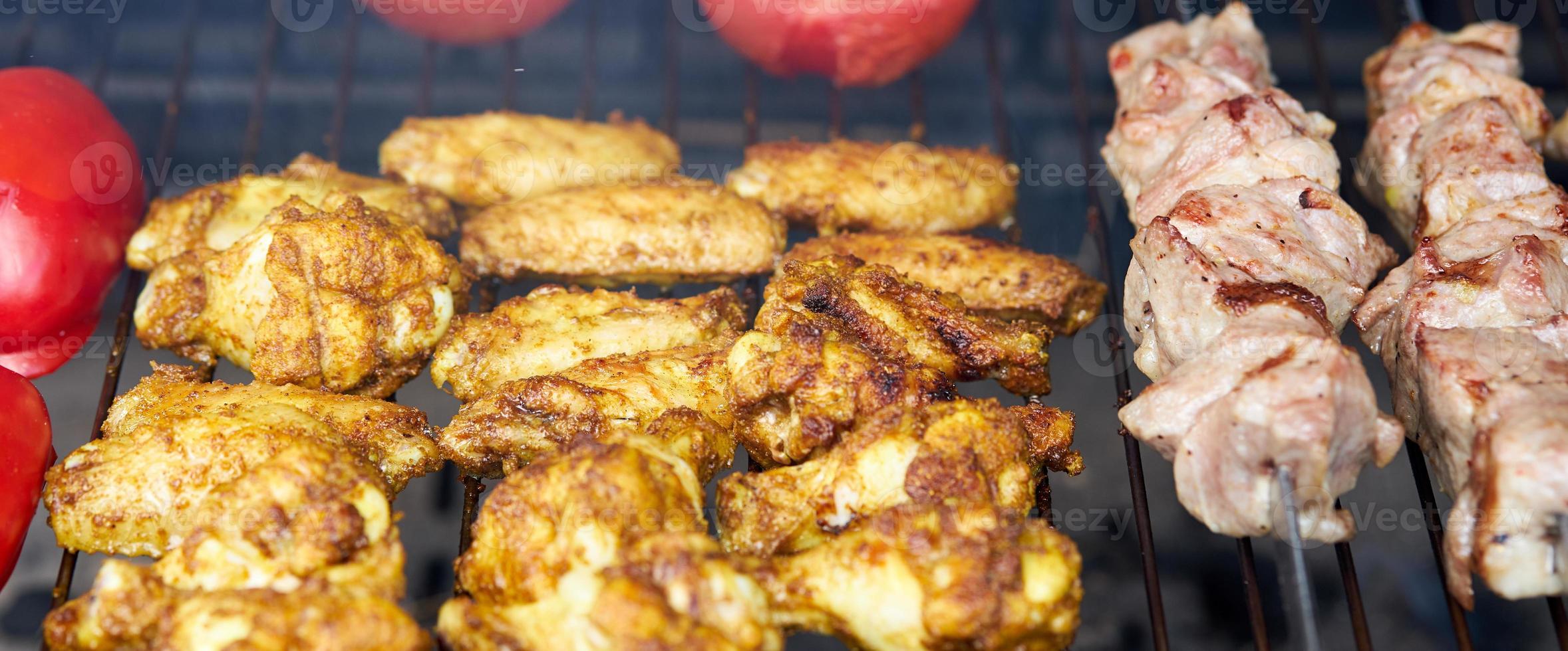 barbacoa shashlik kebab con alitas y tomates con pimiento asado en chargrill semiacabado foto