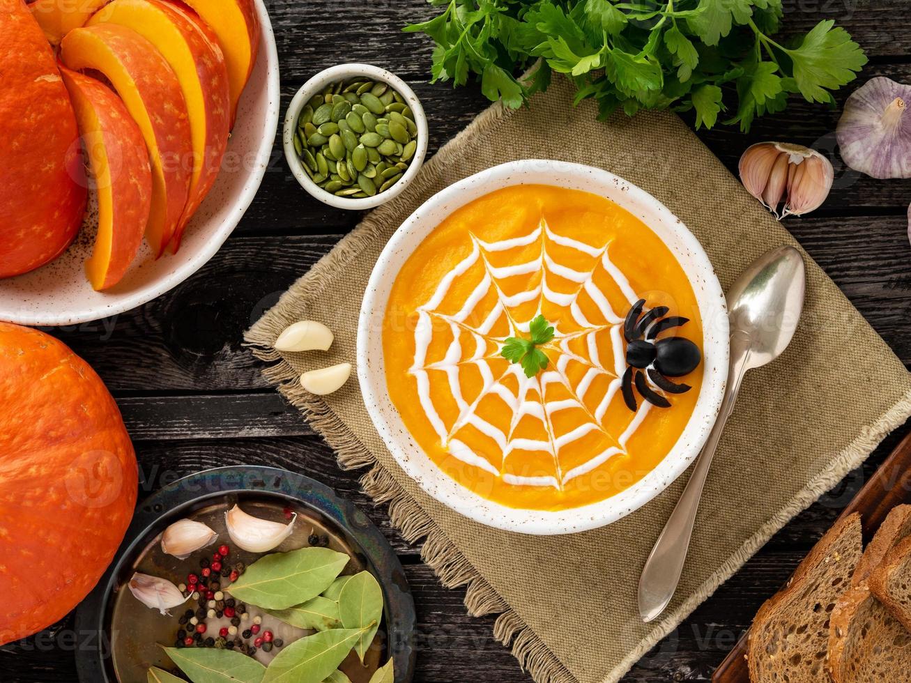 comida divertida para halloween. sopa de puré de calabaza, telaraña, mesa de madera vieja oscura, vista superior. foto