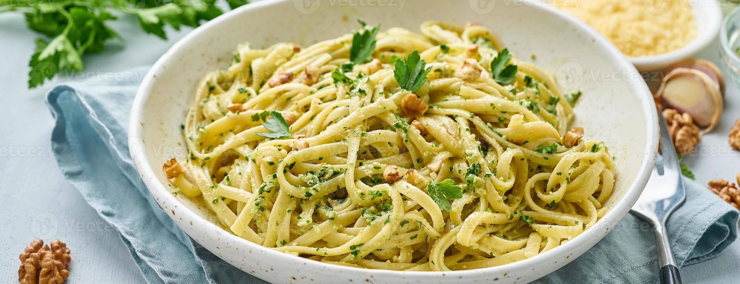 pancarta con pasta al pesto, bavette con nueces, perejil, ajo, nueces, aceite de oliva foto