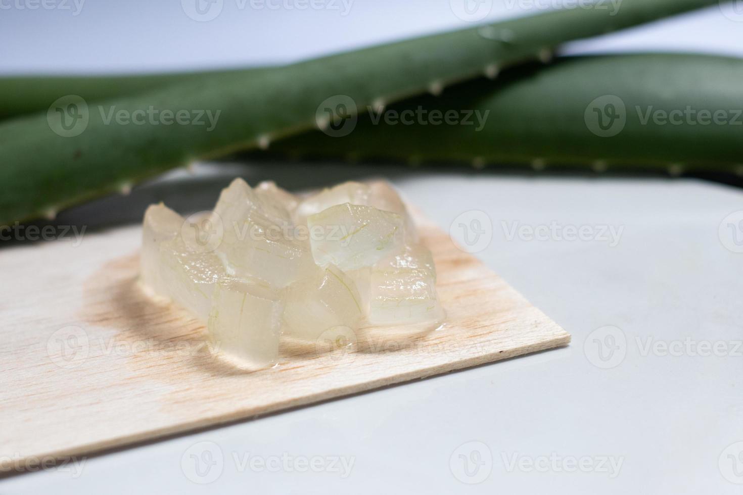 gel de aloe vera sobre placa de madera y fondo blanco, planta cosmética para la piel, tratamiento antibiótico tópico. foto