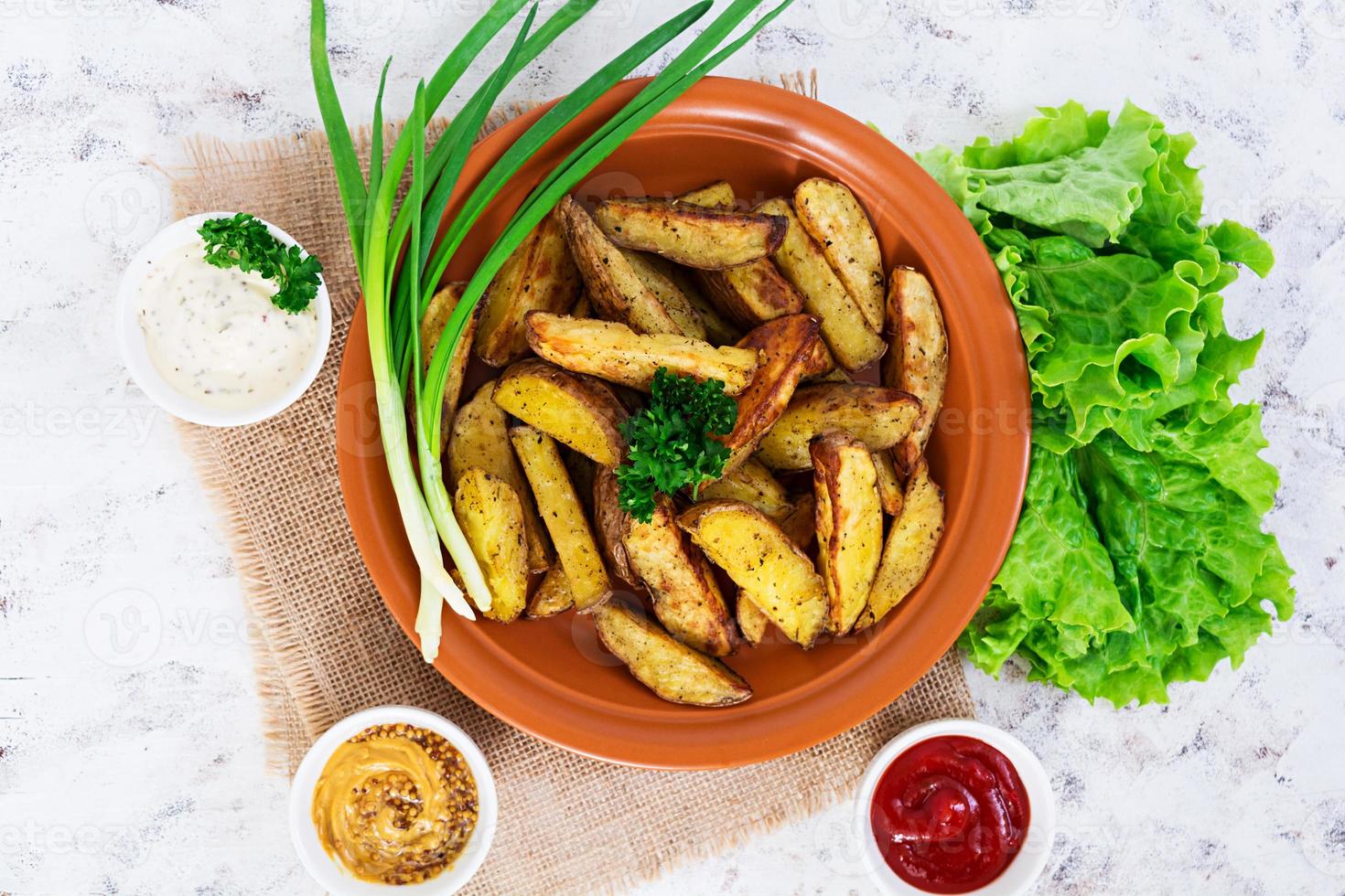 Baked potato wedges with spices. Top view photo