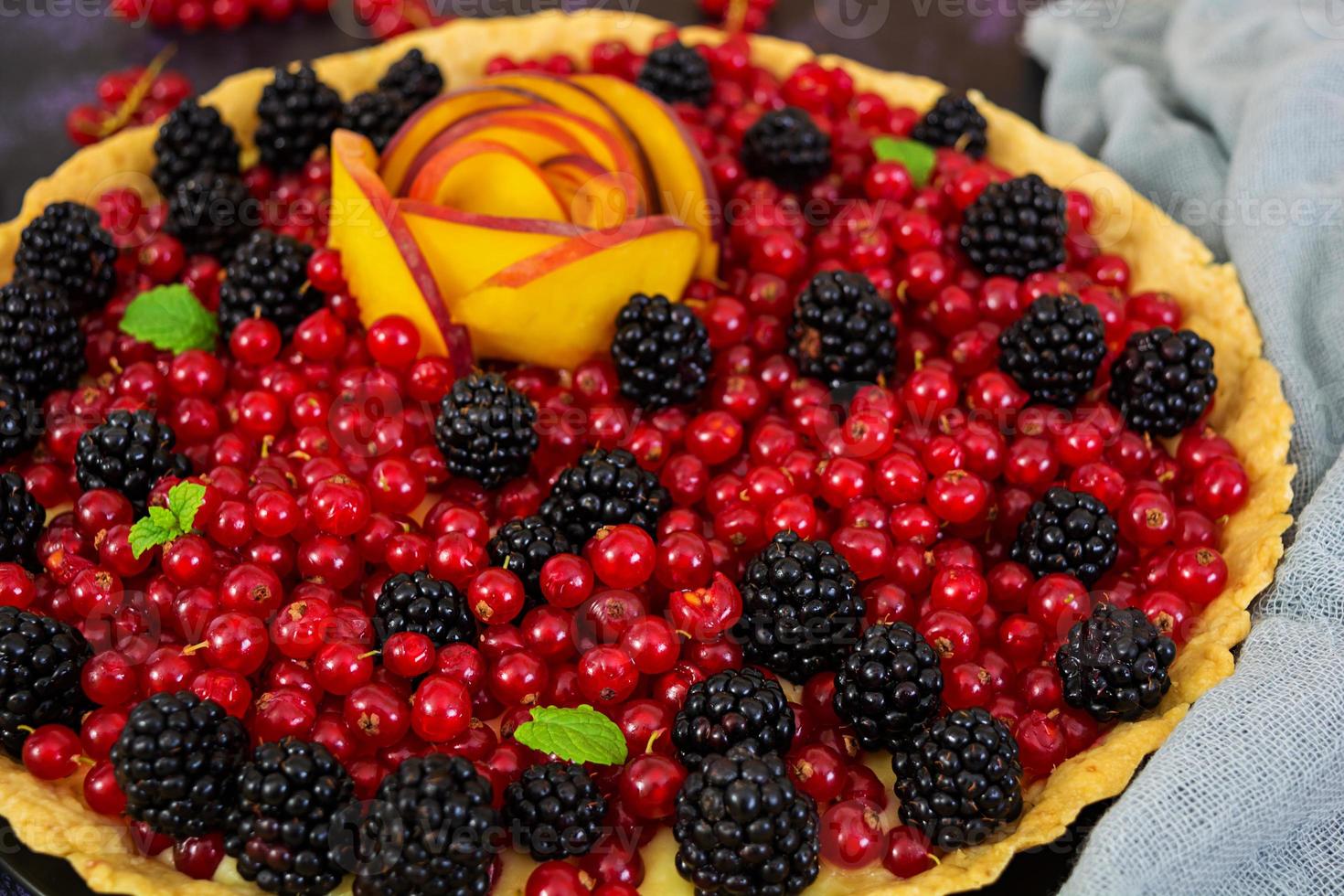 Delicious tart with red currants, peach and blackberries photo