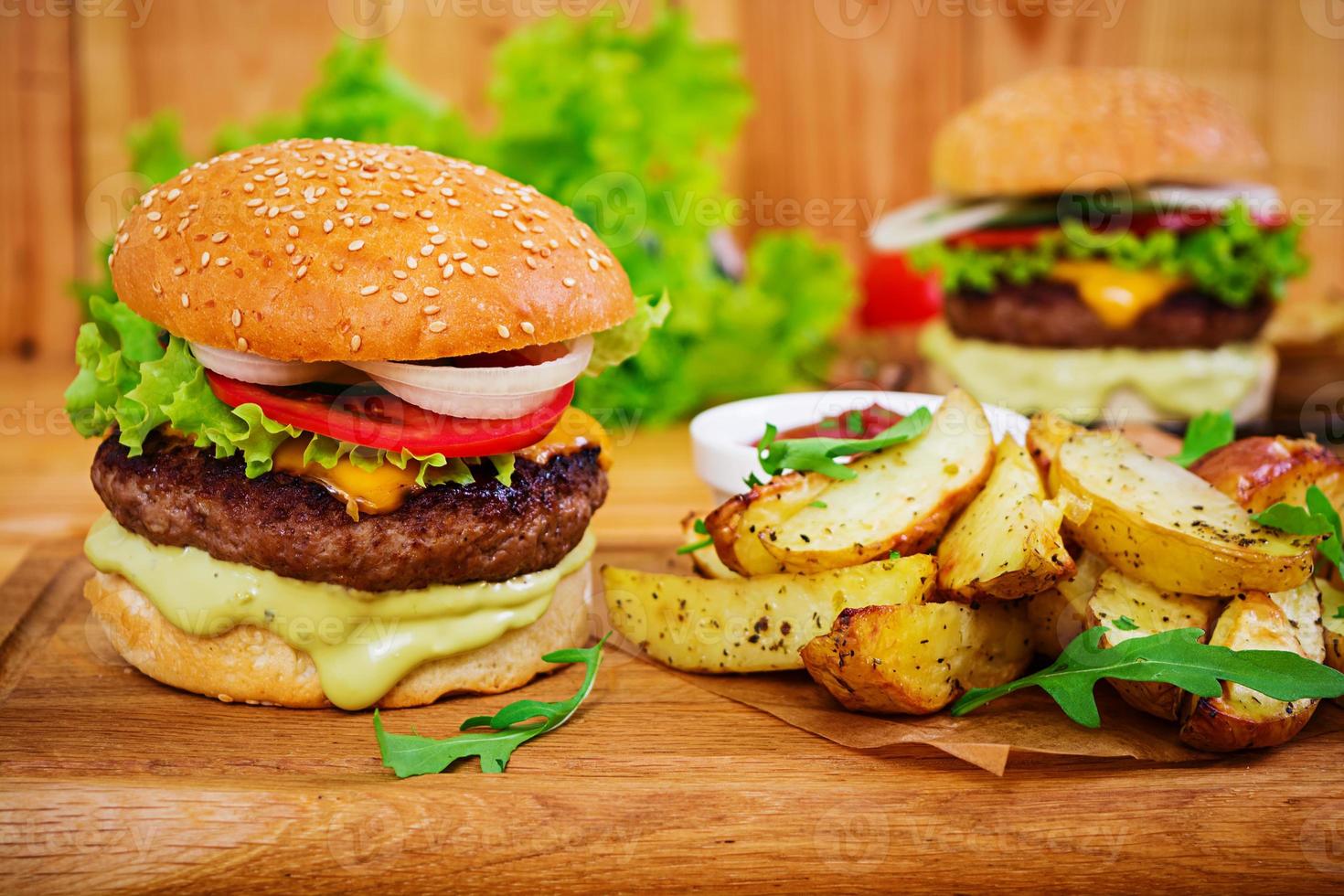 Delicious handmade burger on wooden background. Close view photo