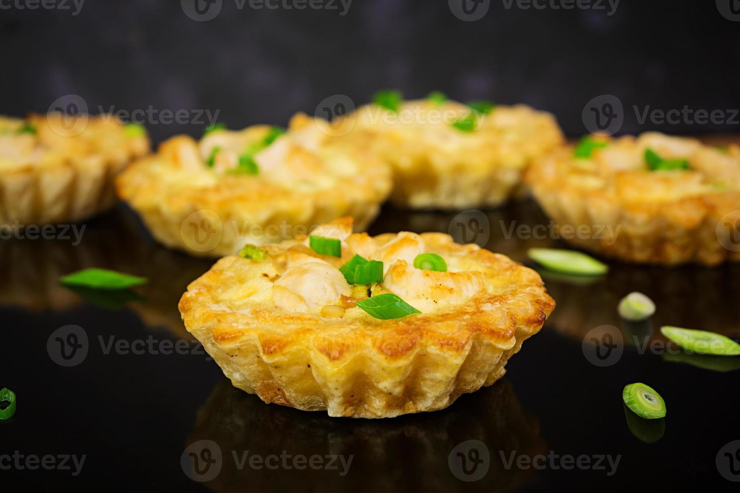 Tartlets with chicken and zucchini on dark background photo