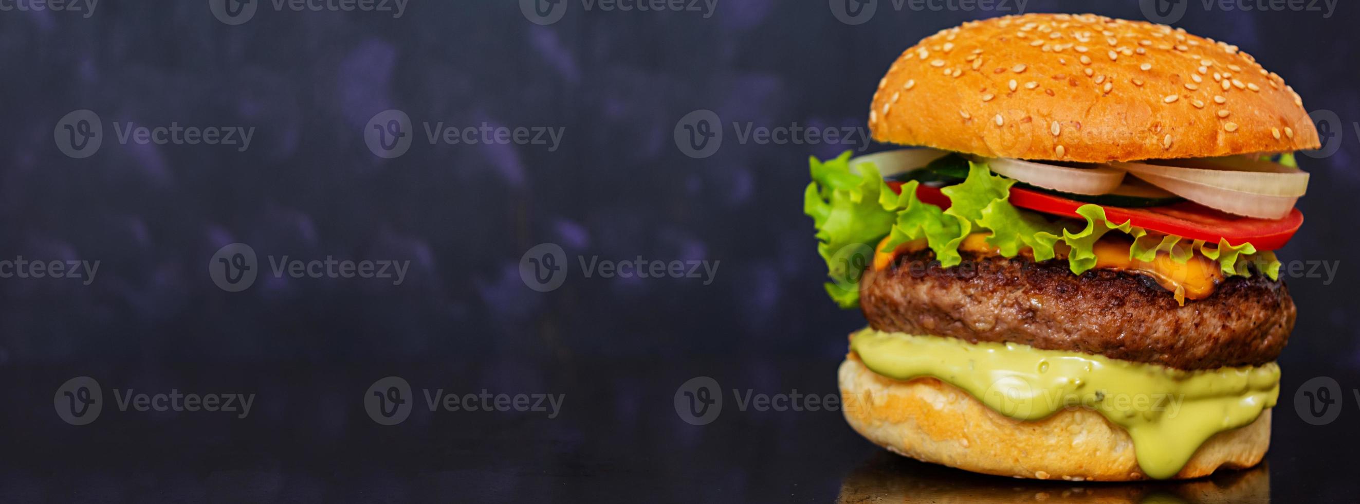 Delicious handmade burger on dark background. Banner. photo