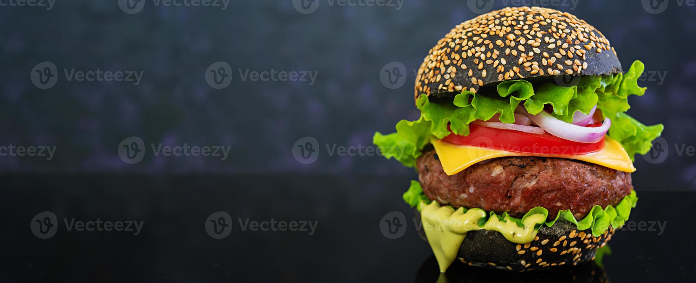 Delicious handmade burger on dark background. Banner. photo