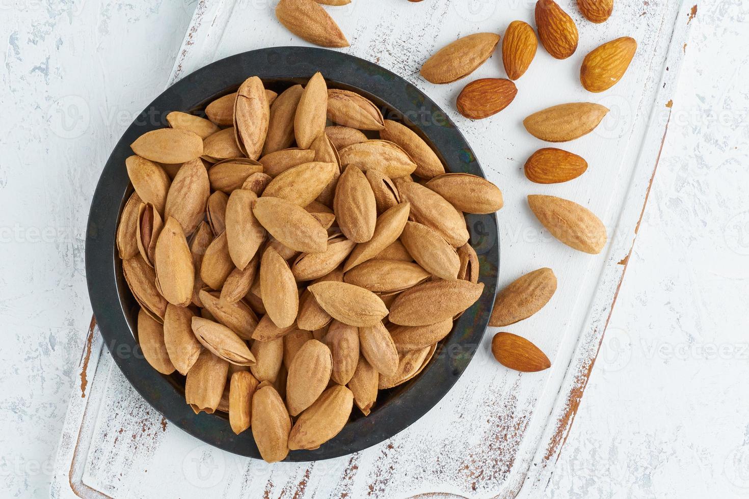 plato de vista superior con almendras en endocarpio, tazón con drupa en cáscara en foto