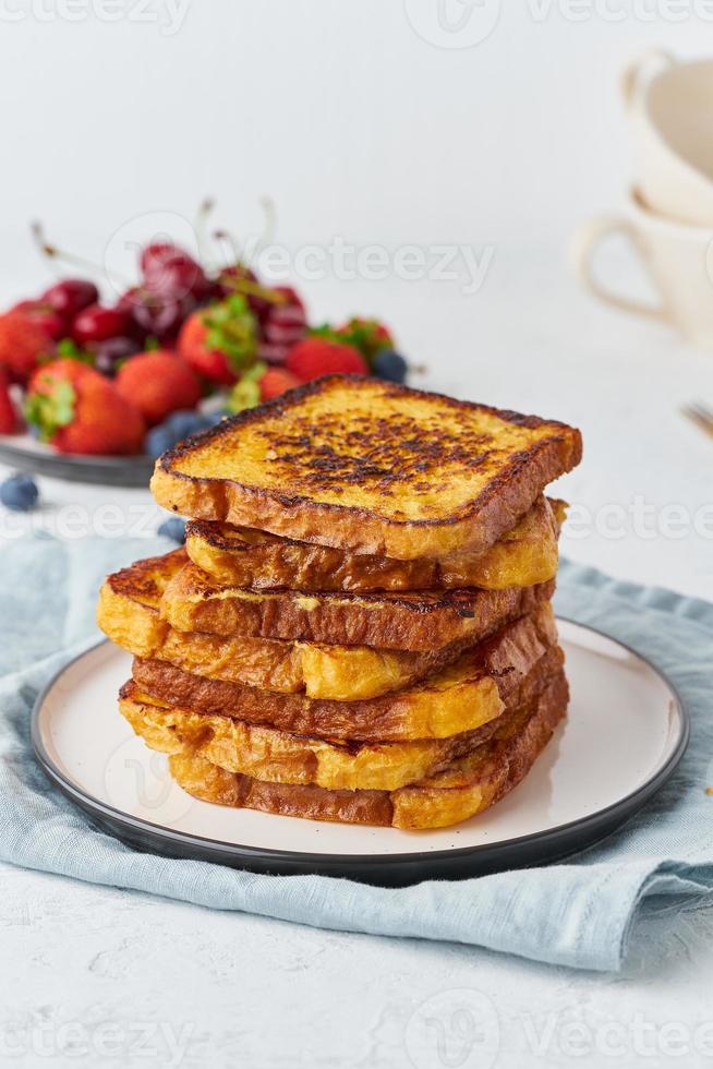 tostadas francesas con bayas, desayuno brioche, fondo blanco, cierre vertical foto