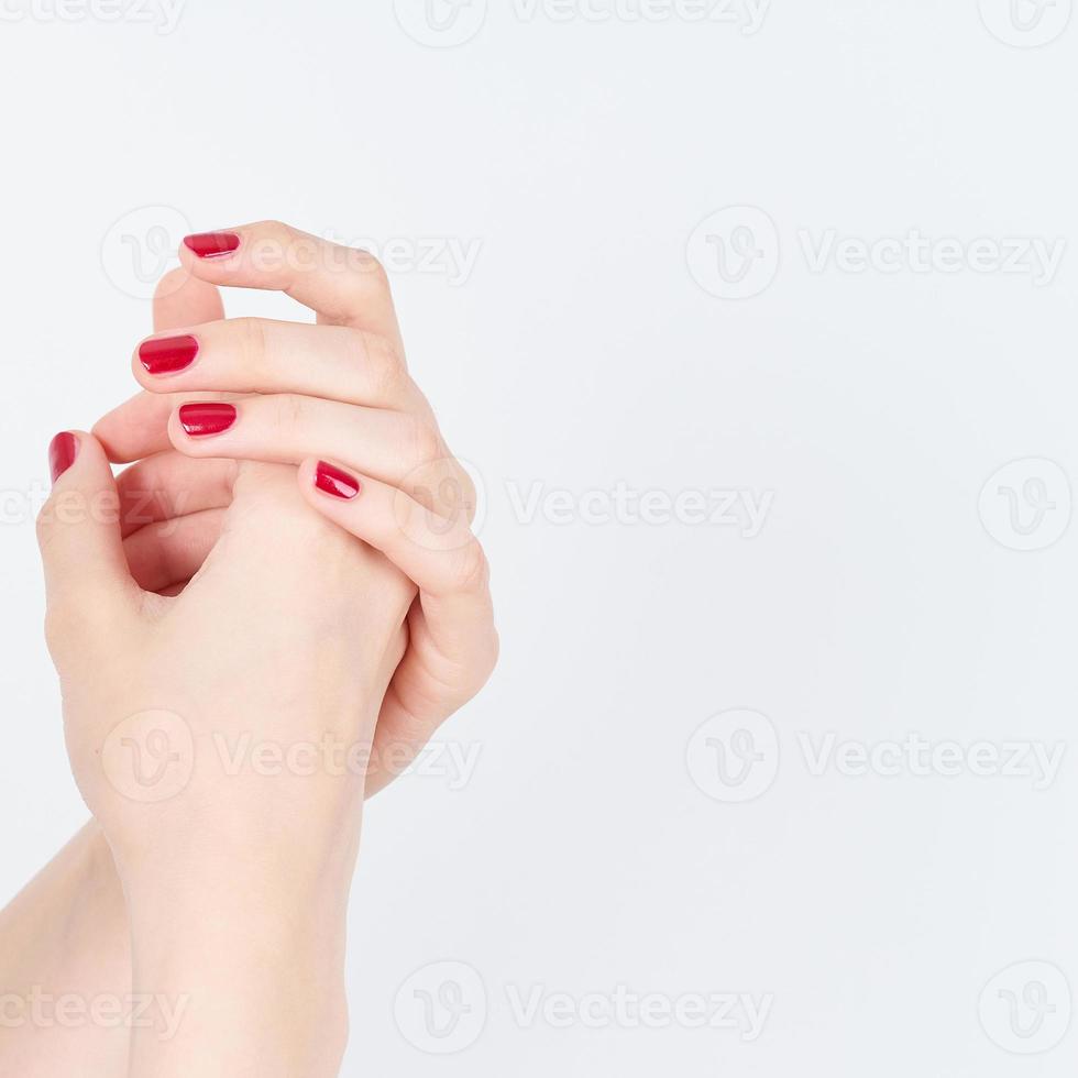 woman showing manicures hands with red nail polish on white background copy space photo