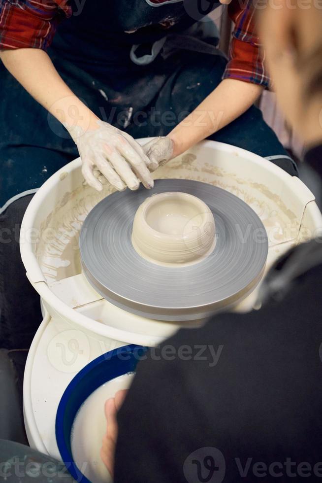 Woman making ceramic pottery on wheel, hands closeup. Concept for woman in freelance photo