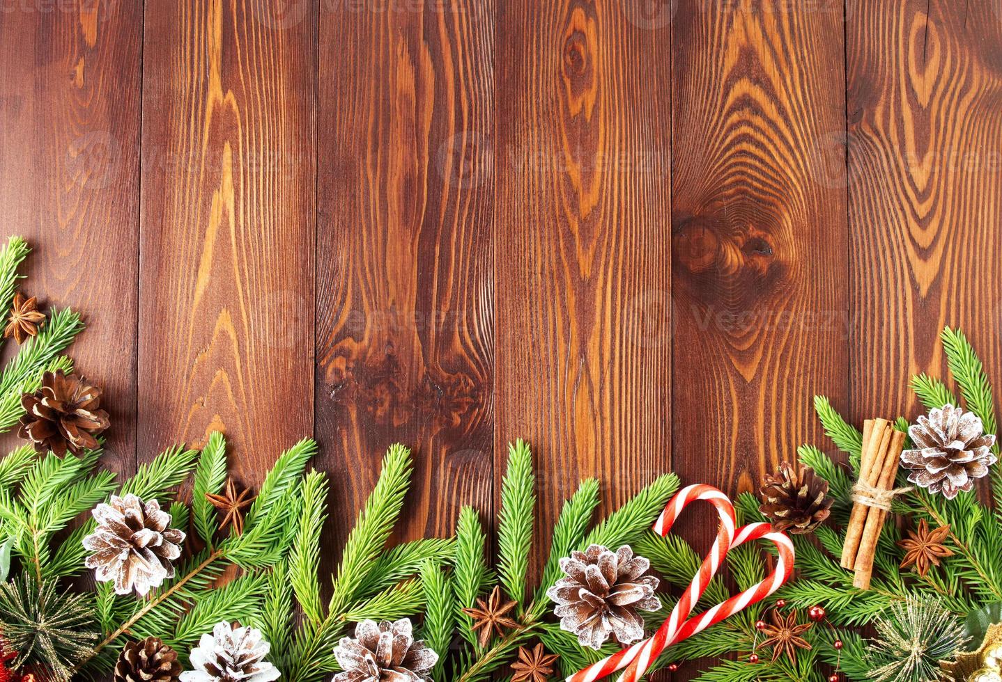 navidad y feliz año nuevo fondo marrón oscuro. vista superior, espacio de copia, mesa rústica de madera, ramas de abeto foto