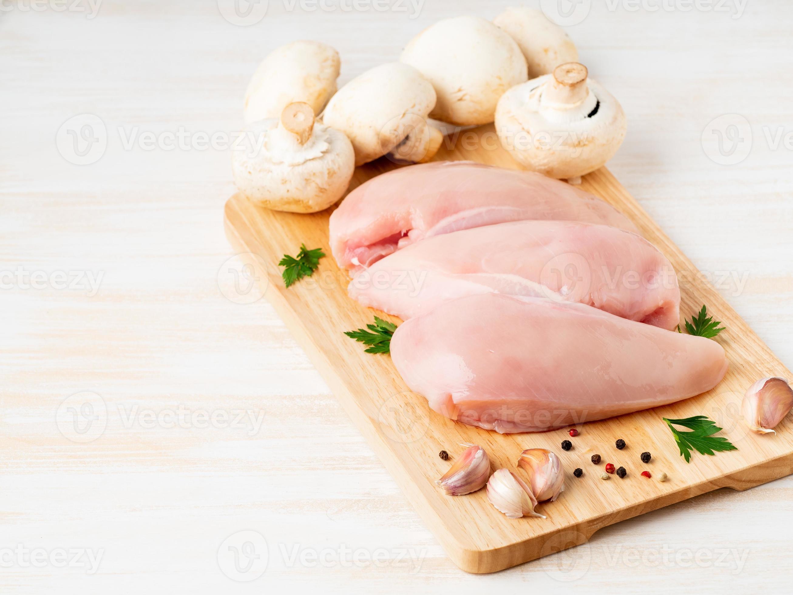 raw chicken breast fillet with spices on wooden board on white wooden table  7460826 Stock Photo at Vecteezy