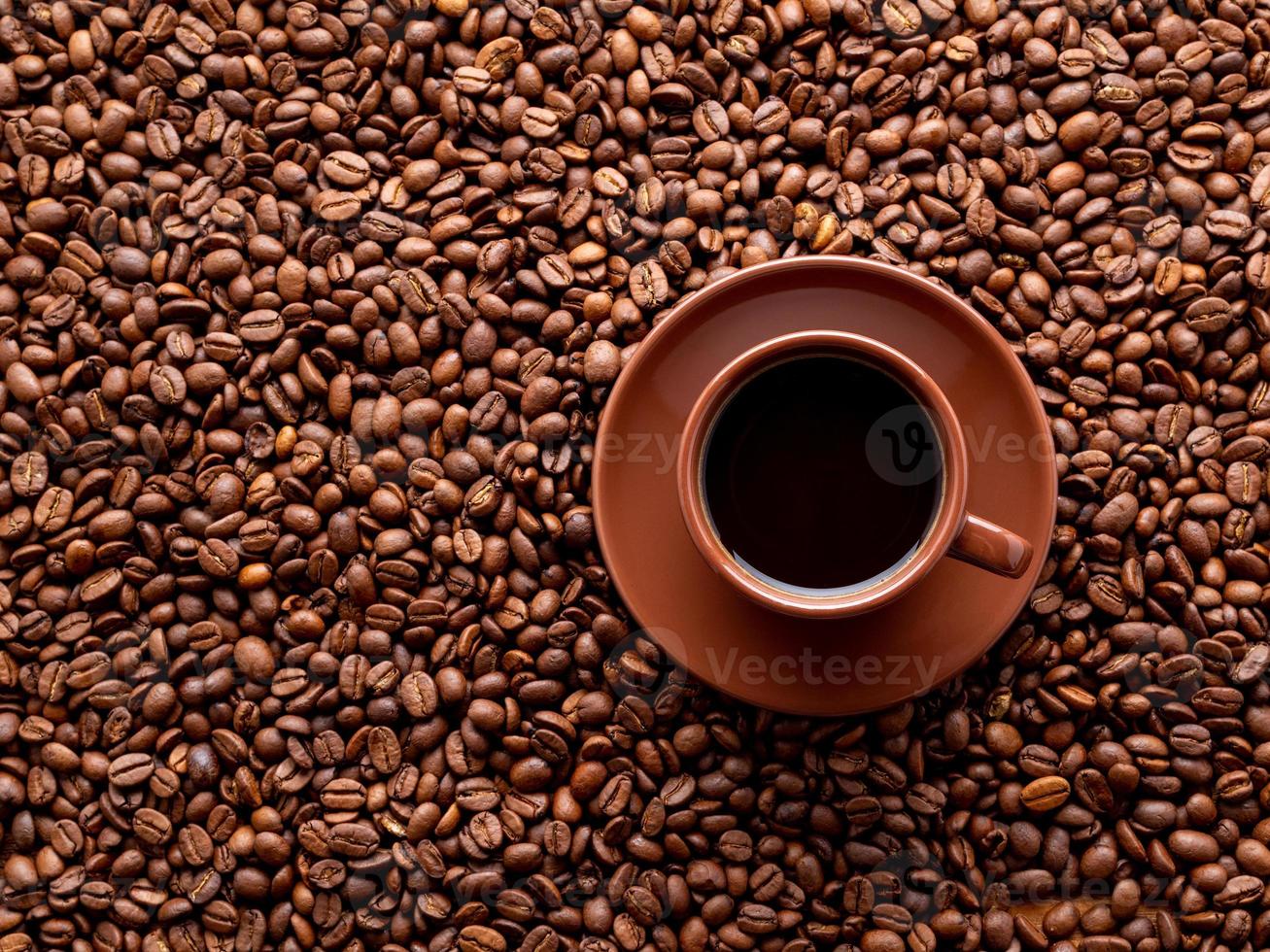 brown cup of espresso on background of scattered coffee beans, top view, copy space photo