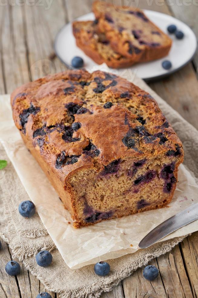 Banana bread on old wooden rustic table, slice of cake with banana, vertical photo