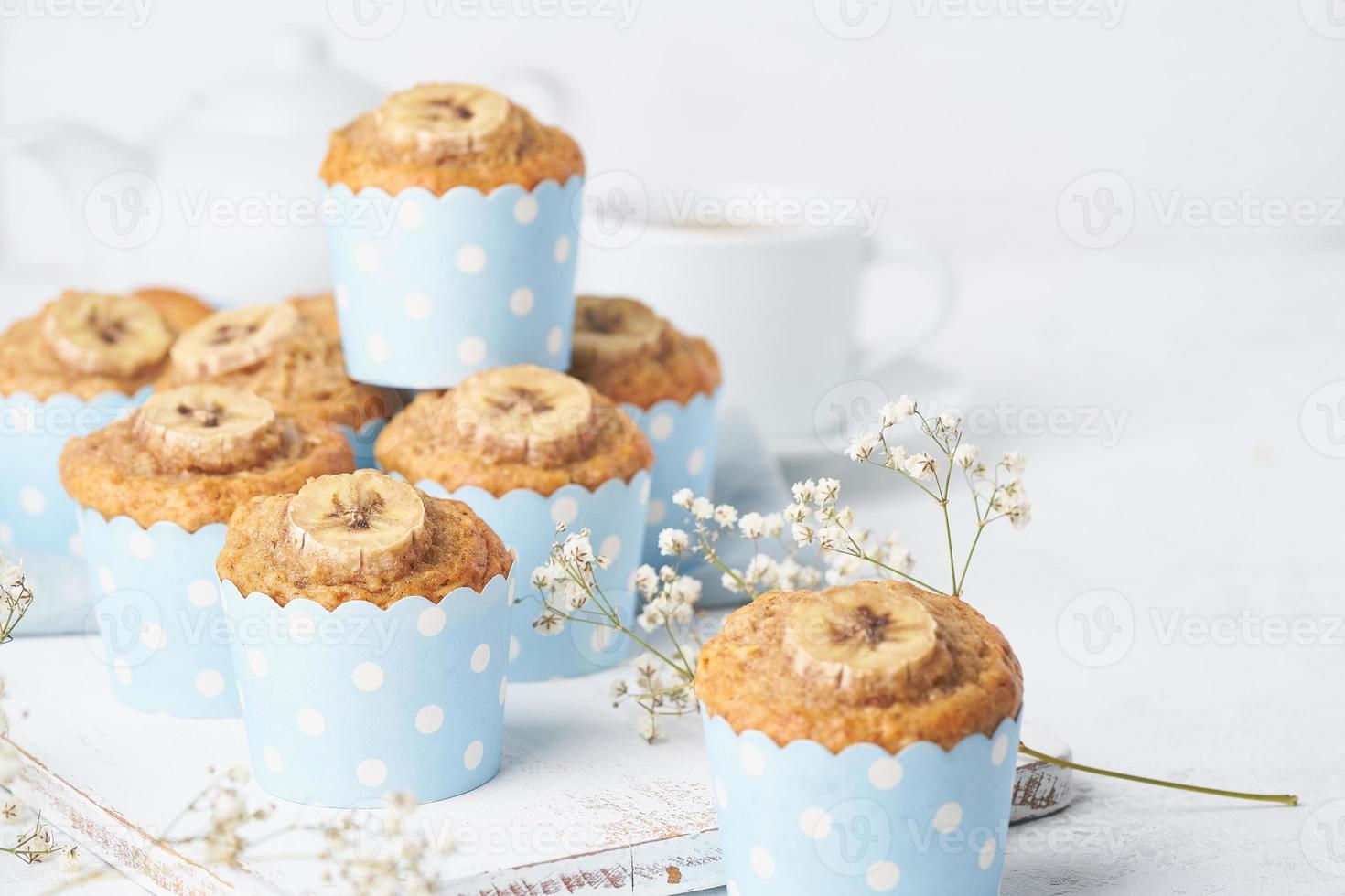 Banana muffin in blue cake cases paper, side view, close up, copy space. Morning breakfast photo