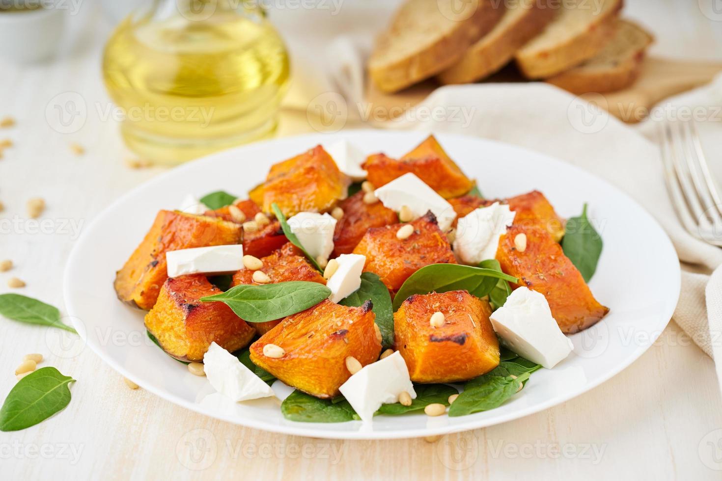 ensalada con calabaza asada, queso feta, espinacas, nueces con miel y condimentos, vista lateral foto