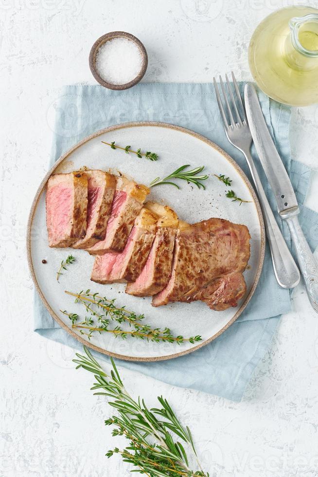 Filete de ternera cetogénico dietético, lomo en placa gris sobre fondo blanco. receta de comida paleo foto