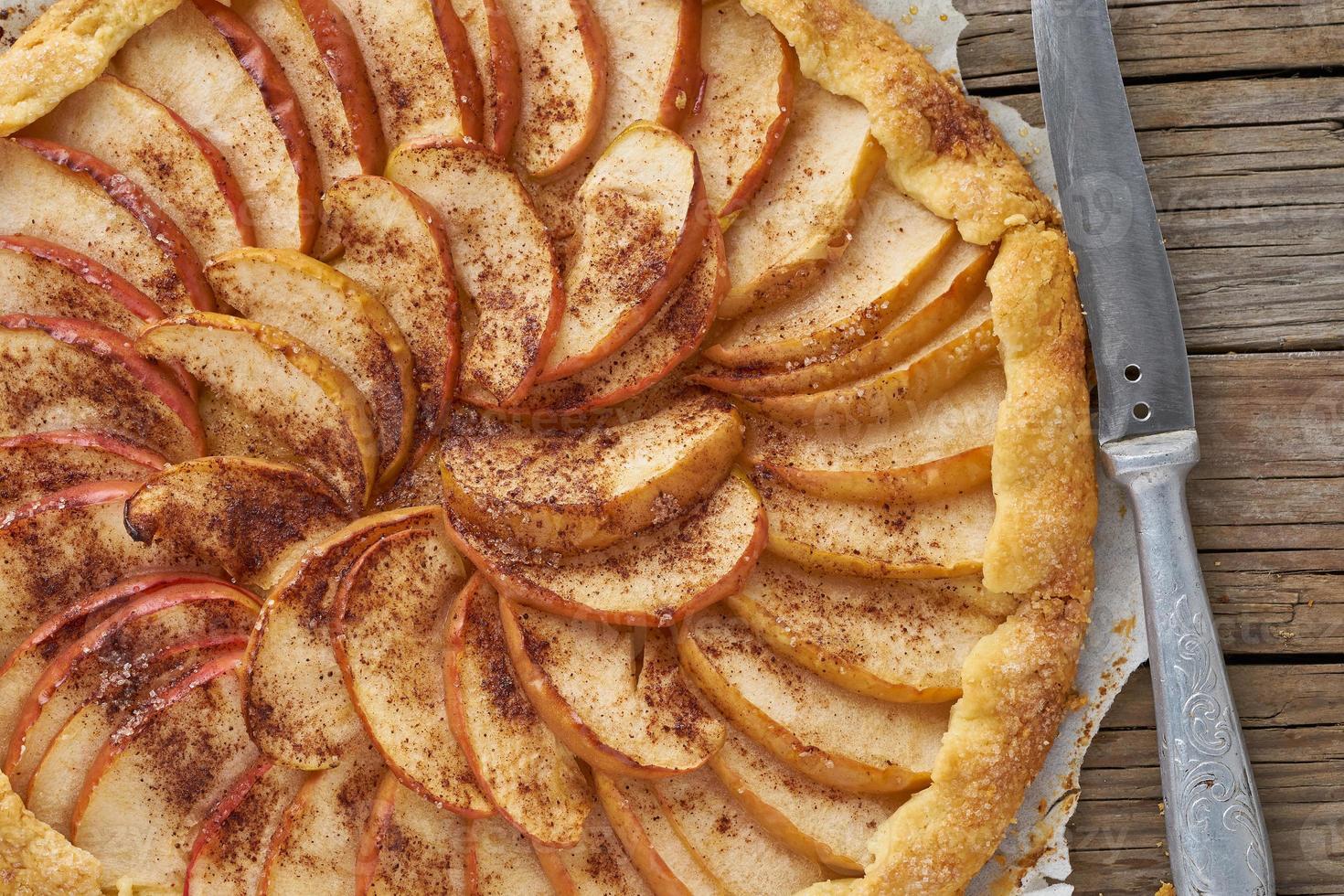 Apple pie, galette with a fruits, sweet pastries on old wooden rustic table. Close up photo