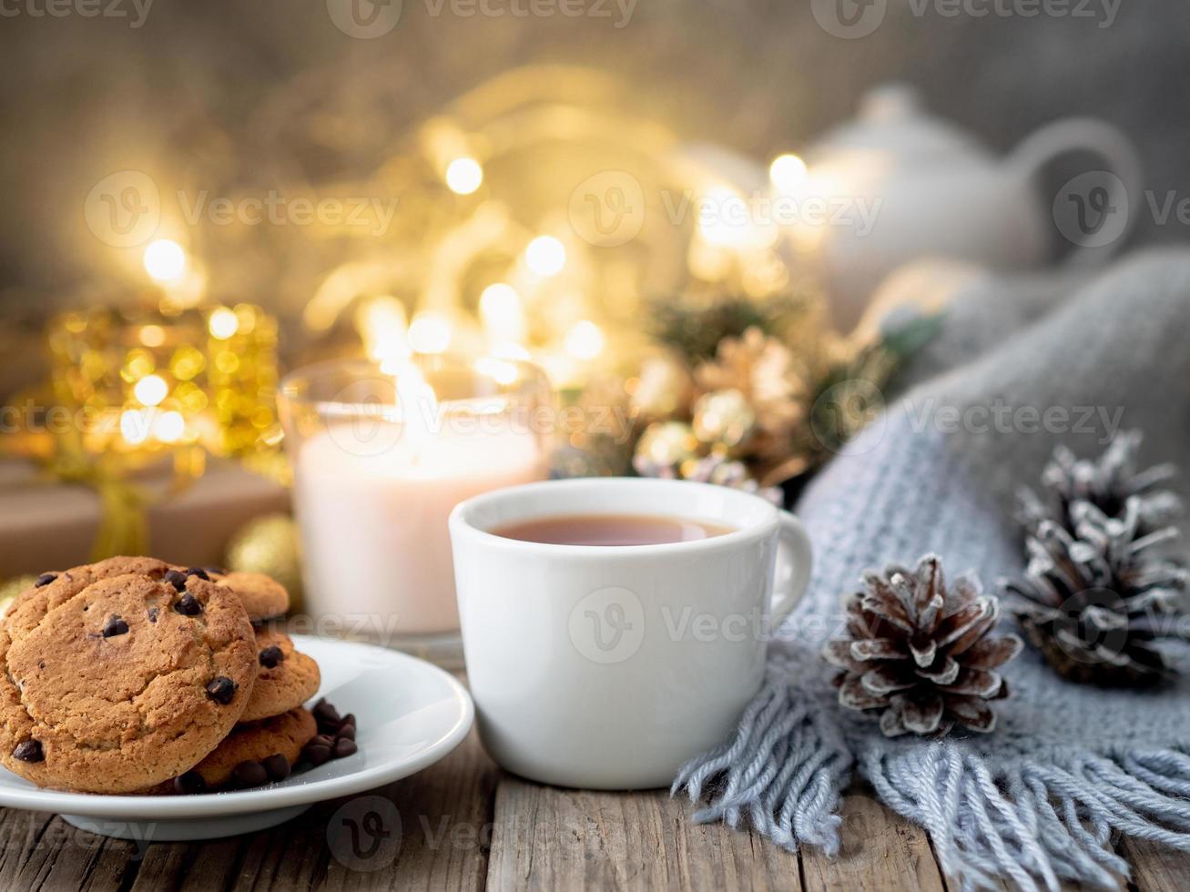 Cozy evening, cup of drink, Christmas decorations, candles and lights garlands photo