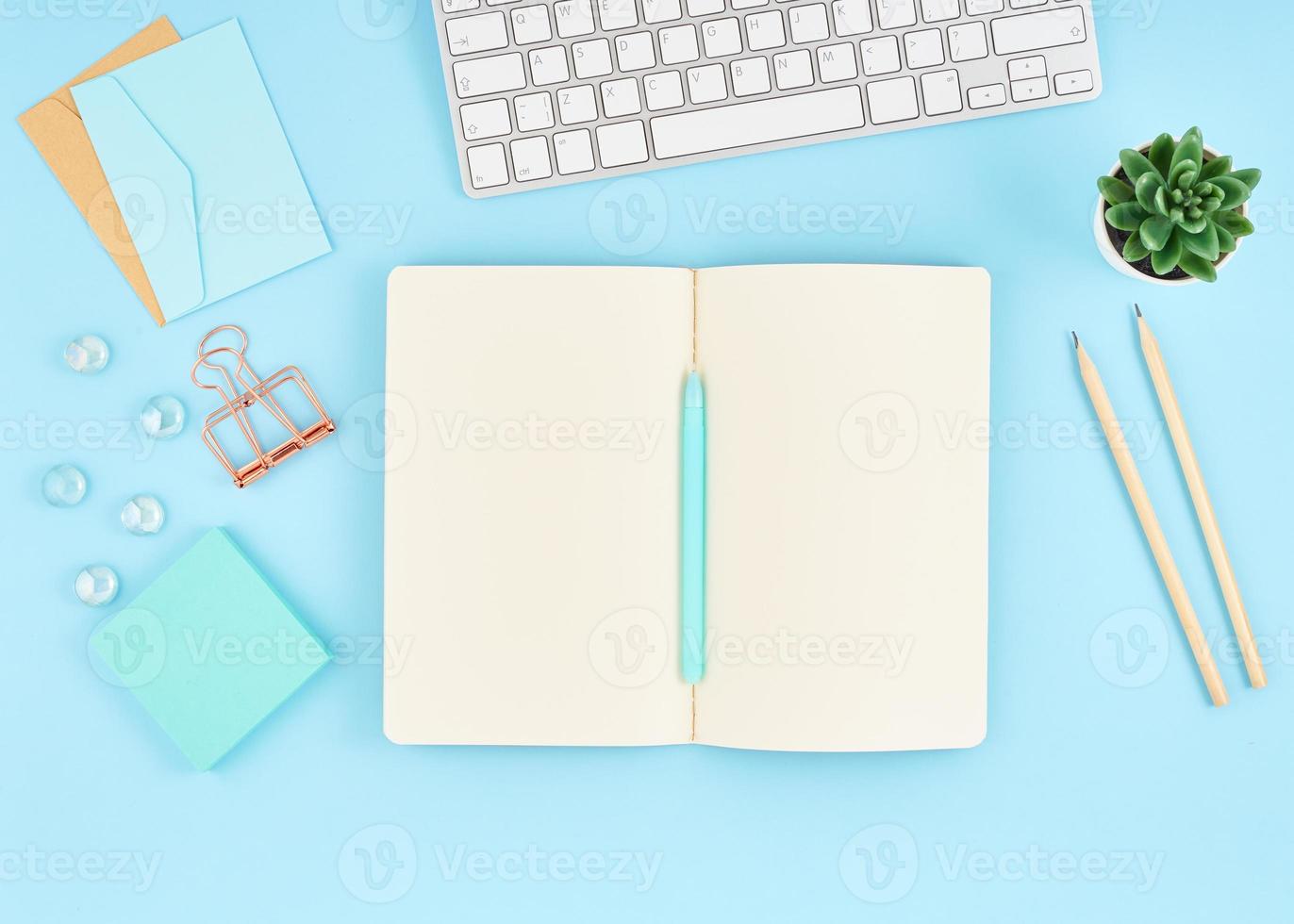 Blank notepad page for text on blue office desktop. Top view of modern bright table photo