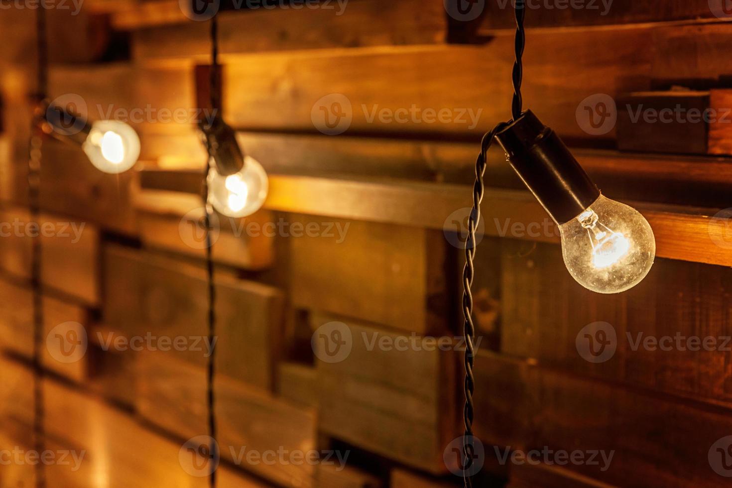 Modern dark classical style interior design apartment with retro lamps hanging light bulbs background. Wooden planks with lamps. Decorated interior room with gold lights. Copy space mockup poster. photo