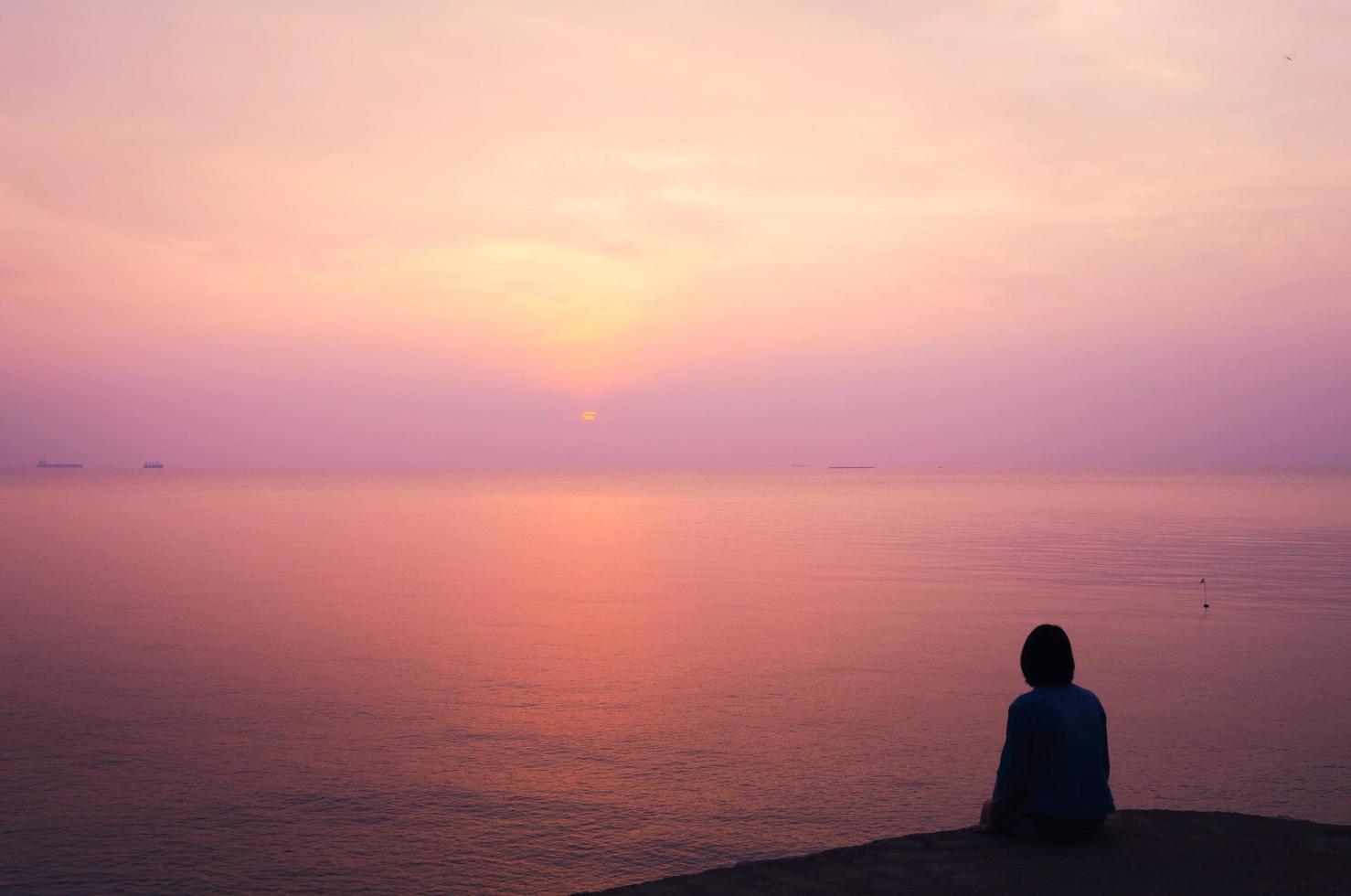 Woman on holiday, looking to sea with beautiful view in the evening. Sunset at the island, romantic background concept. photo