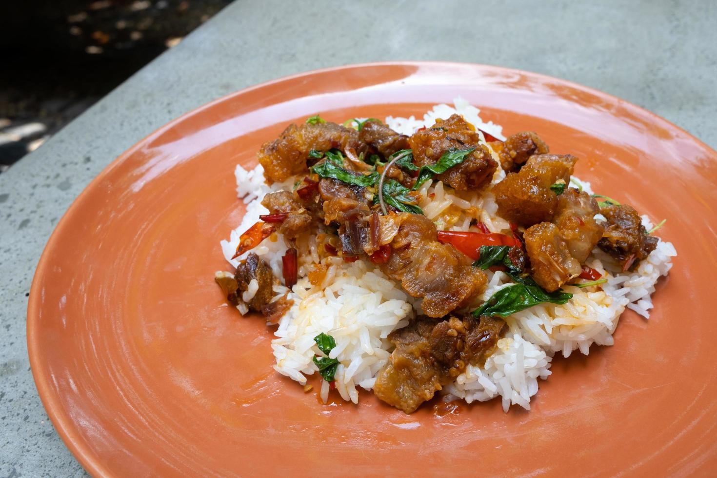 la comida callejera más favorita y popular o comida casera de tailandia, panceta de cerdo crujiente con albahaca salteada sobre arroz. tiene un sabor picante, salado, dulce. comida asiática. foto