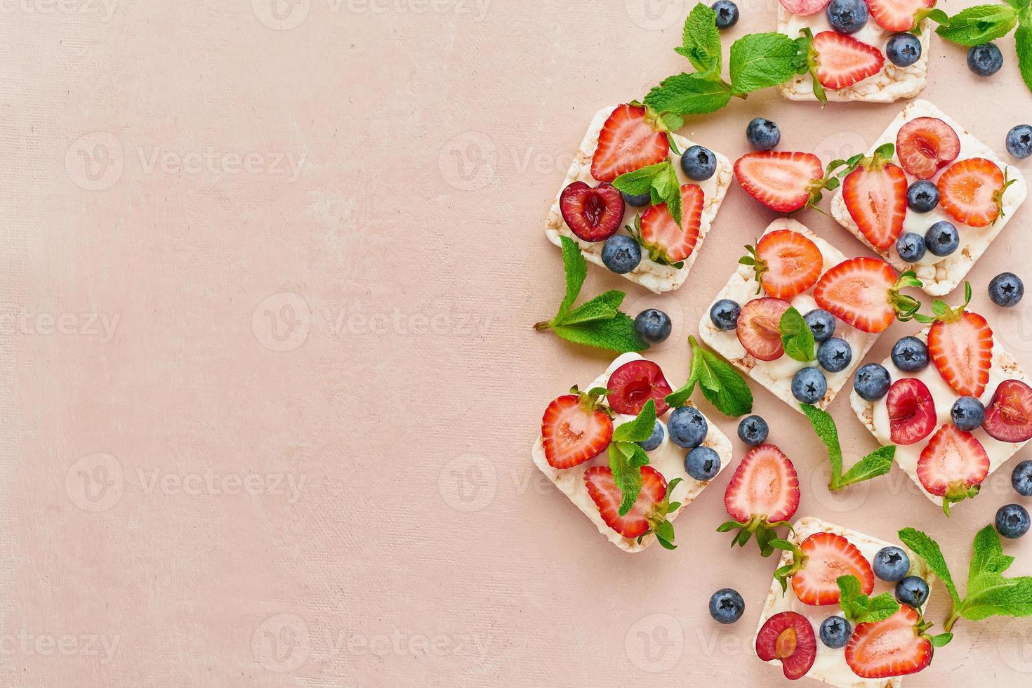 Rise crispbread with berries and fruits colorful concept on terracotta background copy space top view photo