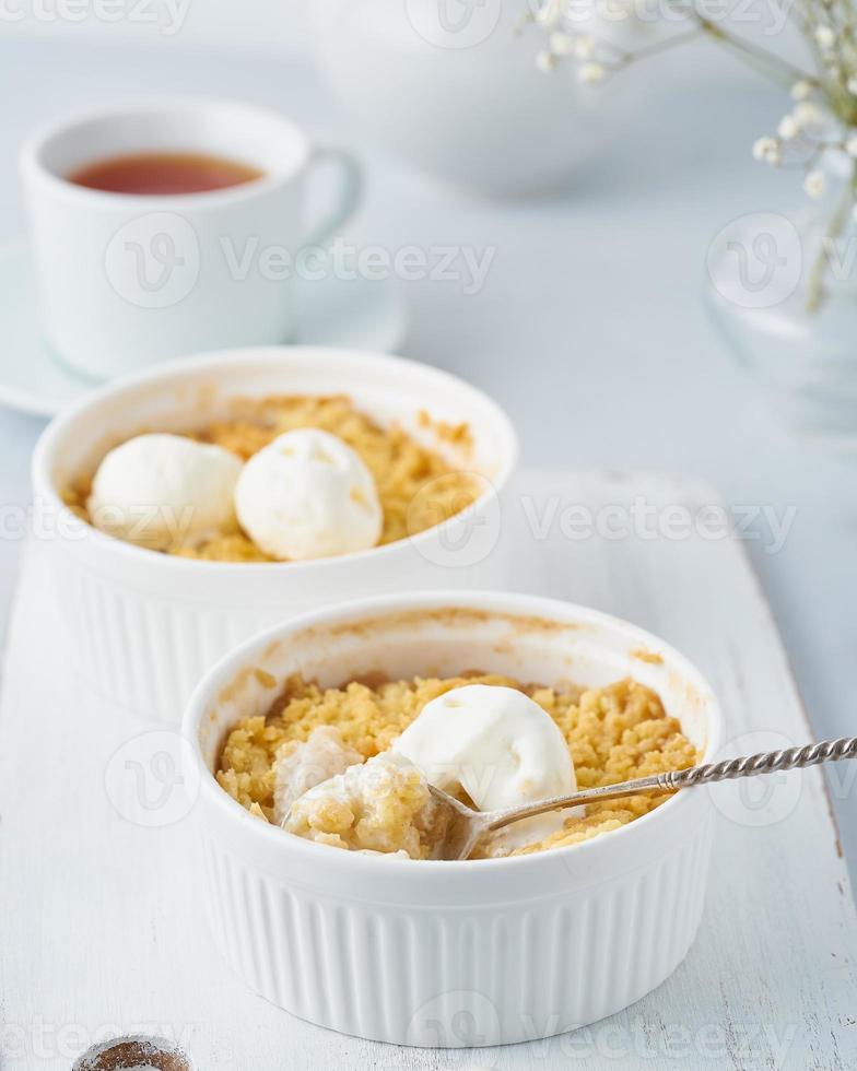 crumble de manzana con helado, cuchara con streusel. vista lateral, verticales. desayuno por la mañana foto