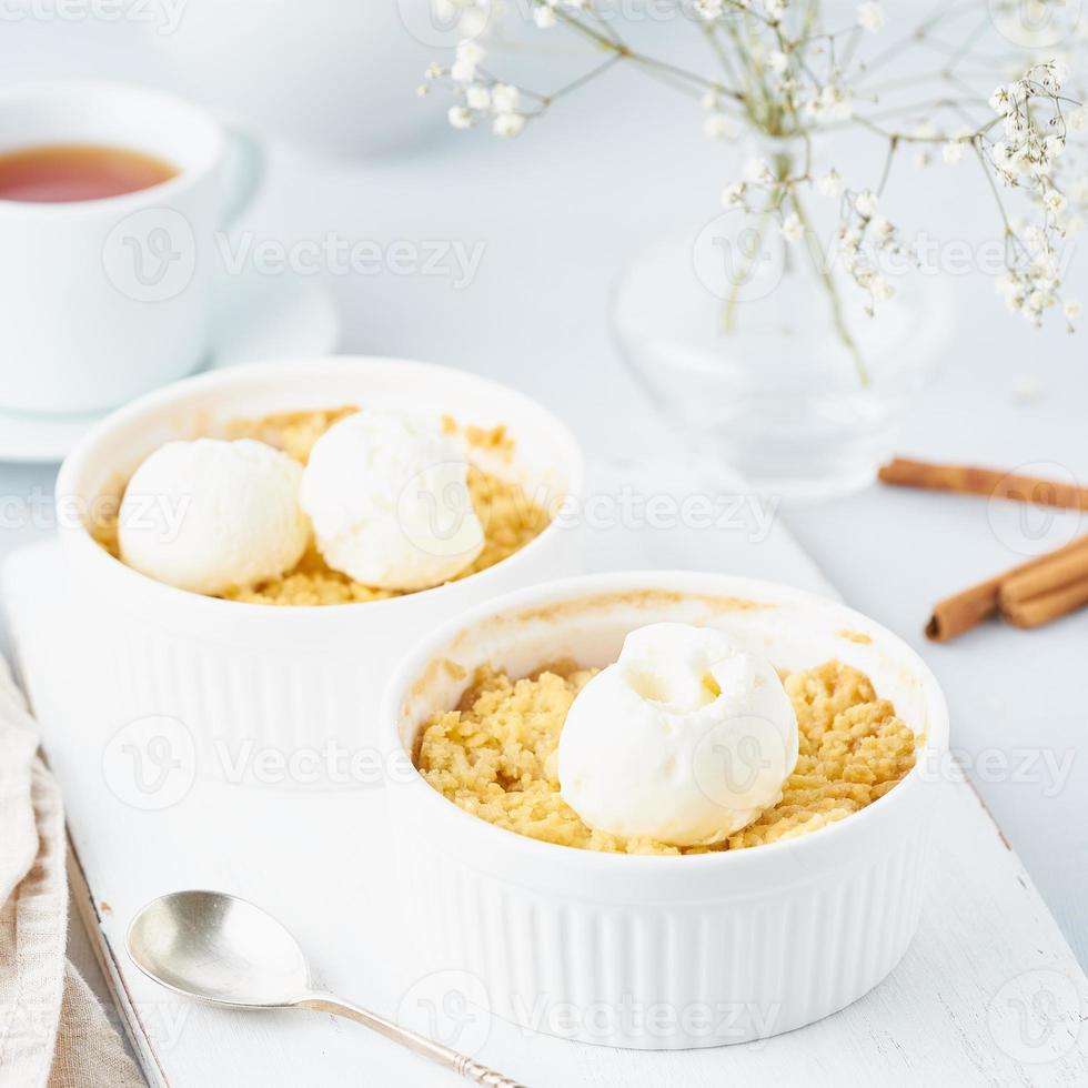 Close up apple crumble with ice cream, spoon with streusel. Side view, vertical photo