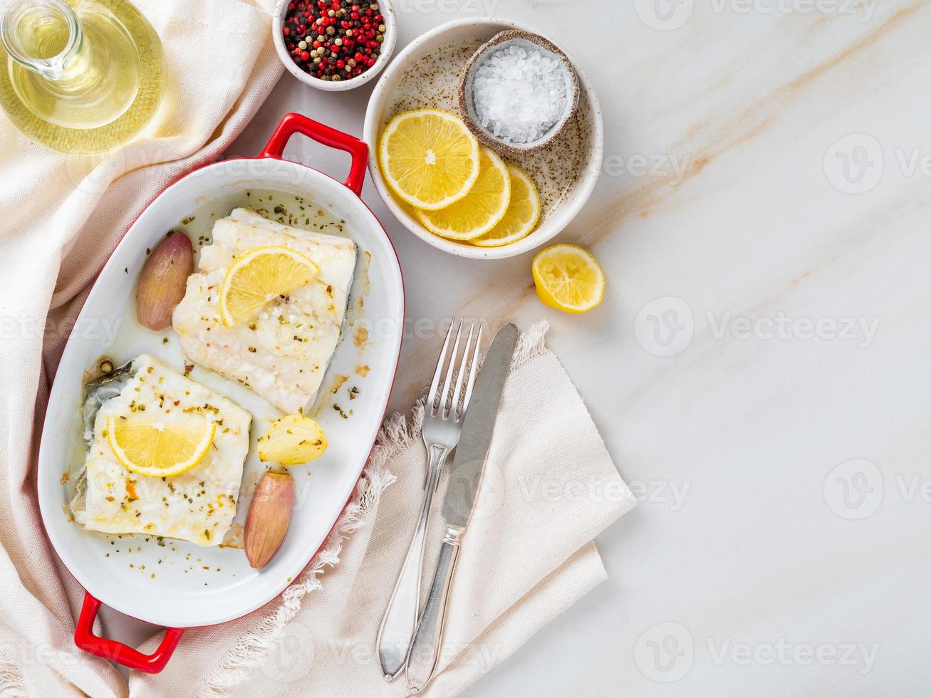 filete de bacalao, recién cocinado al horno con cebolla en plato de porcelana roja para hornear foto