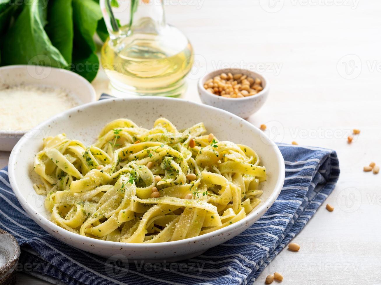 pasta tagliatelle con salsa pesto hecha de albahaca, ajo, piñones, aceite de oliva foto