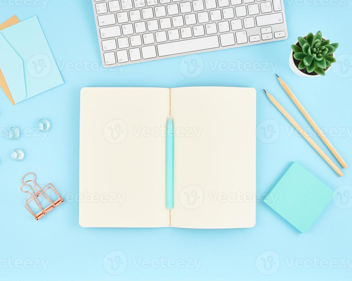 Blank notepad page for text on blue office desktop. Top view of modern bright table photo