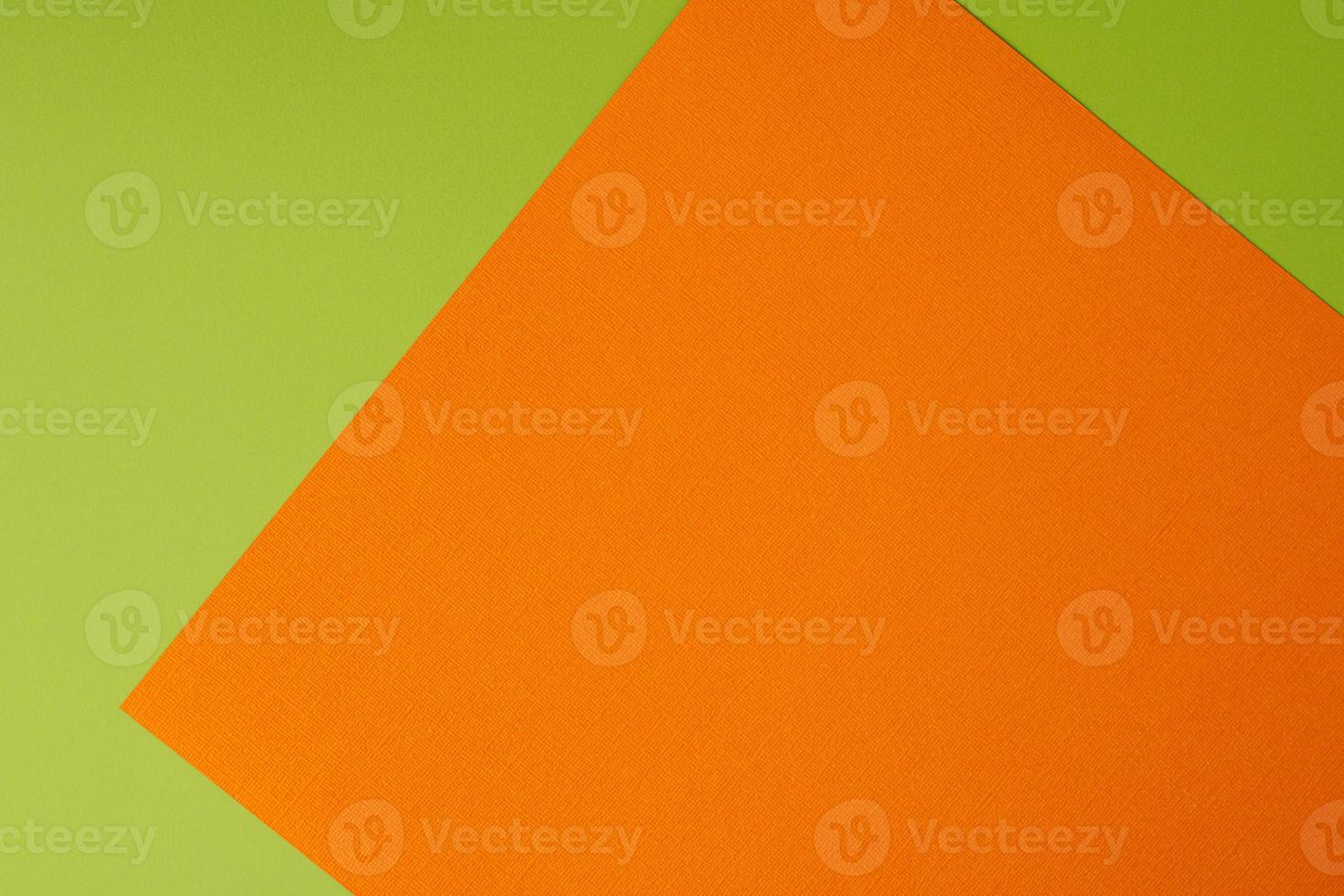 Orange and green colored background of layered cardboard sheets, top view, copy space photo