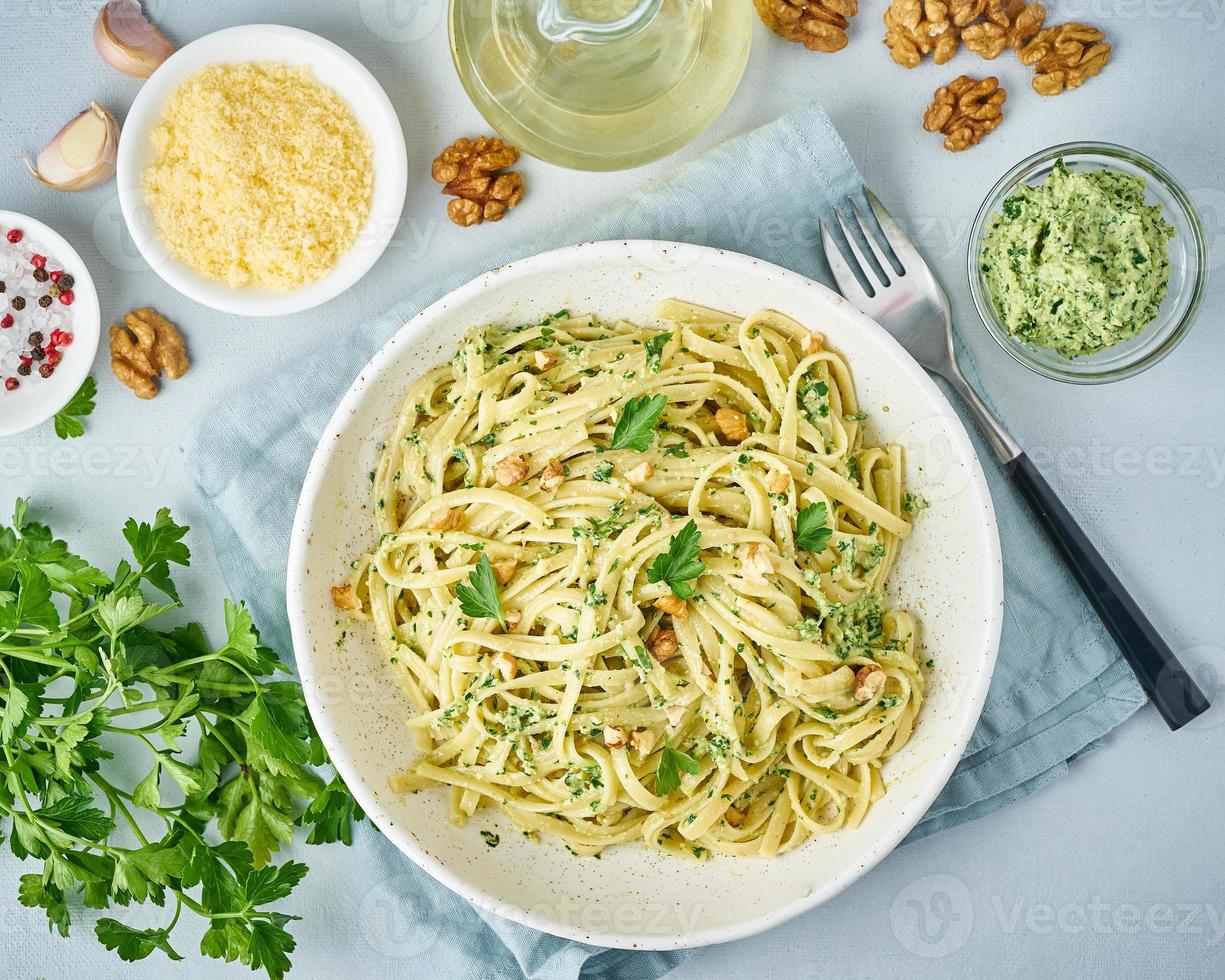 Pesto pasta, bavette with walnuts, parsley, garlic, nuts, olive oil. Top view, close-up photo