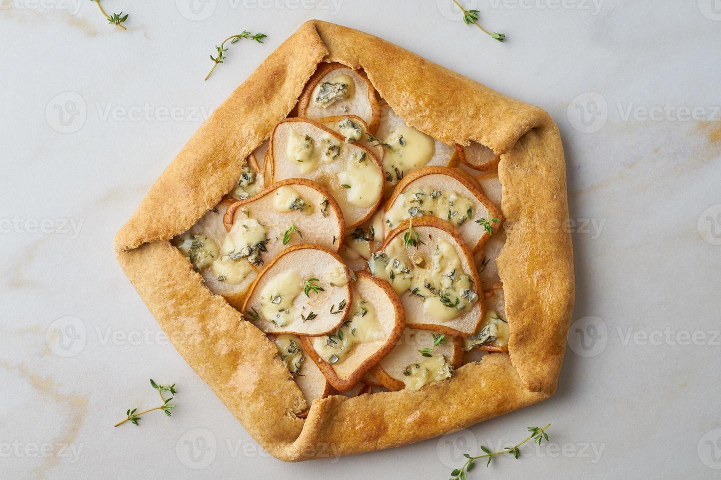 galett de pera con queso azul, tarta salada, mesa de mármol, vista superior foto