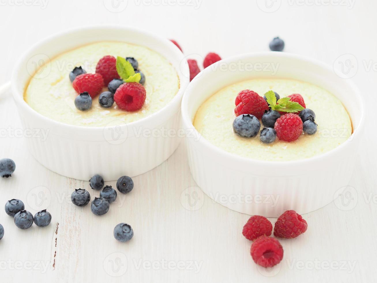 cheesecake decorated with raspberries, blueberries and mint in two ramekin, delicious dessert photo