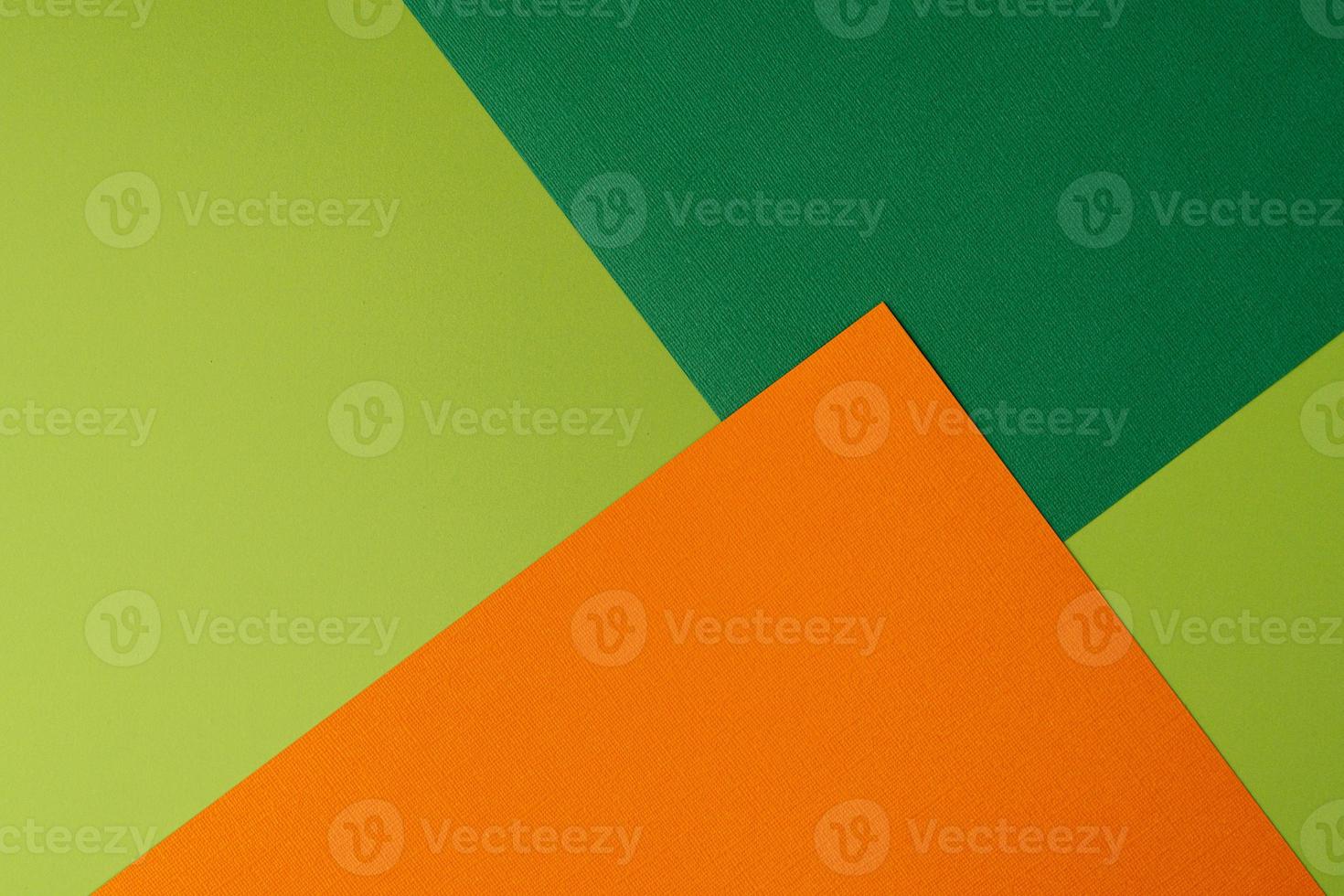 Colorful overlapped orange and green cardboard layers of paper on background, top view photo