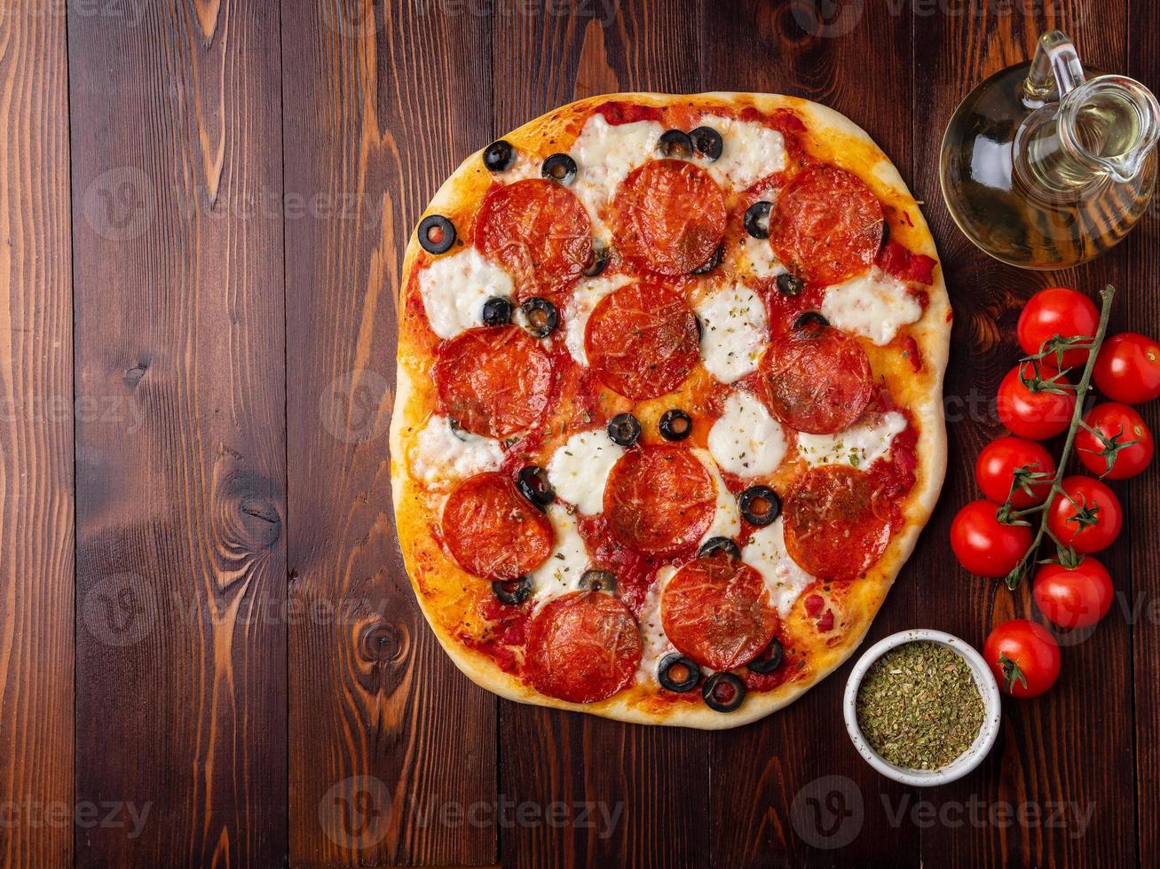 hot homemade Italian pepperoni pizza with salami, mozzarella and olives photo