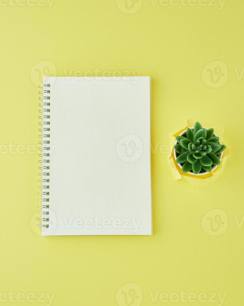 página de bloc de notas en blanco en el diario de viñetas en el escritorio de oficina amarillo brillante. vista superior de la mesa luminosa moderna con cuaderno, minimalismo. maqueta, espacio de copia, concepto de diario foto