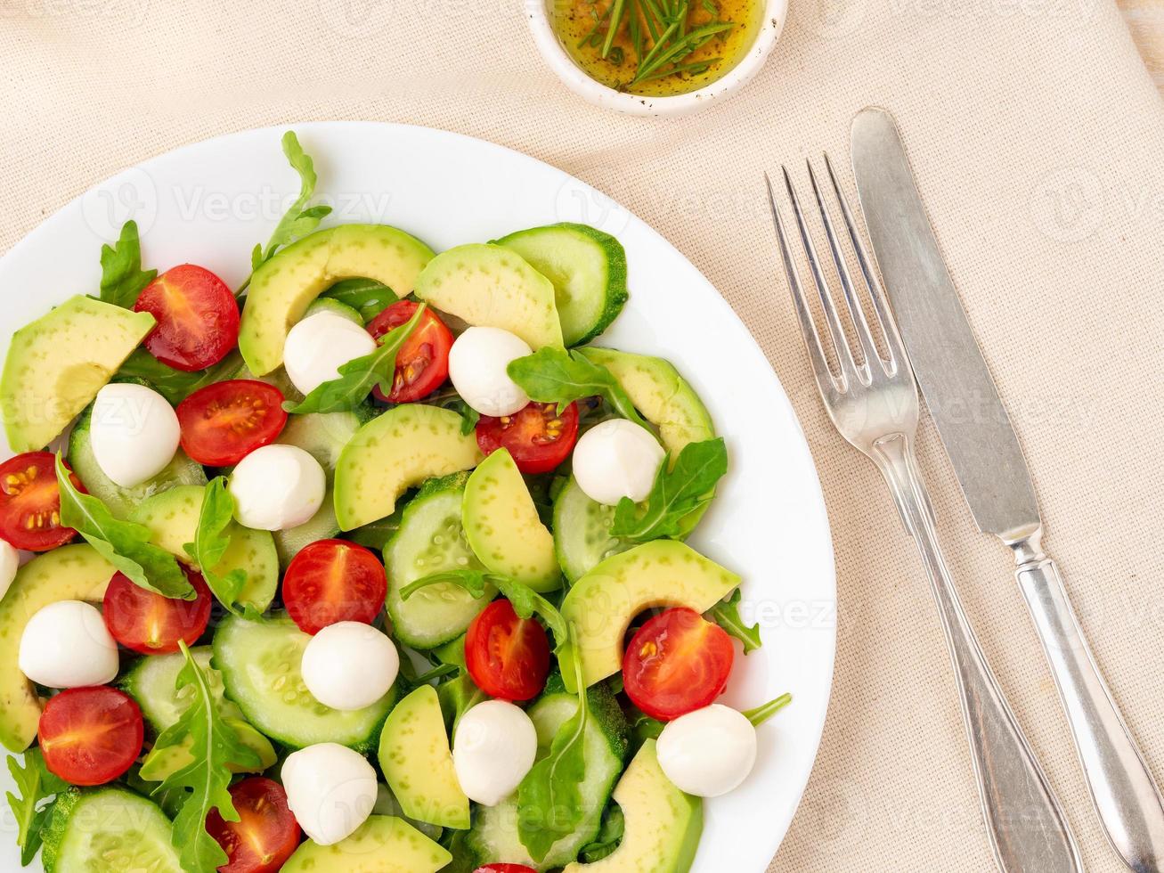 ensalada fresca. tomates, pepinos, rúcula, mozzarella, aguacate. aceite fragante foto