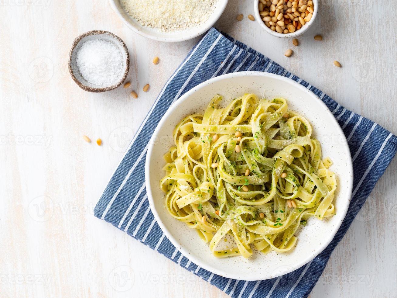 pasta tagliatelle con salsa pesto hecha de albahaca, ajo, piñones, aceite de oliva foto