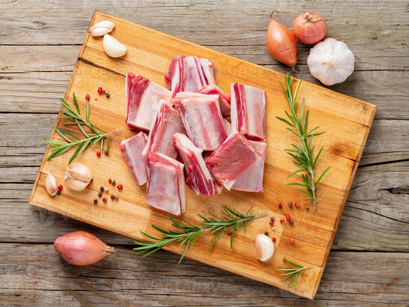 Small pieces of raw lamb ribs on wooden chopping Board photo