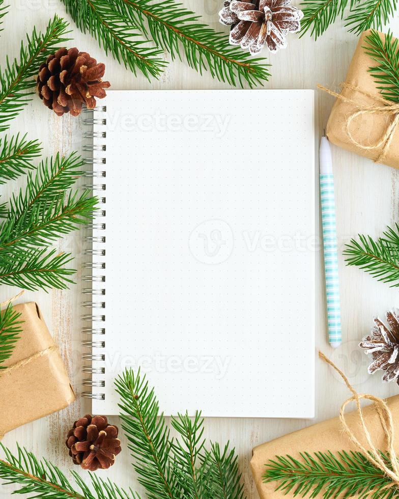 White open notepad, bullet journal for wish list and Christmas decoration on white wooden background, flat lay, copy space. Hand crafted, plastic free, zero waste concept. Mock up photo