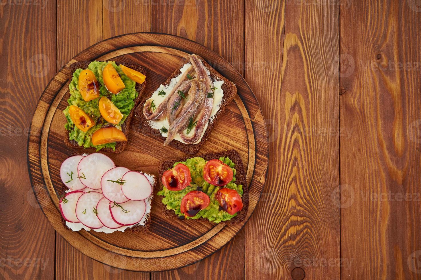 Smorrebrod - traditional Danish sandwiches. Black rye bread with fish, vegetables, copy space photo