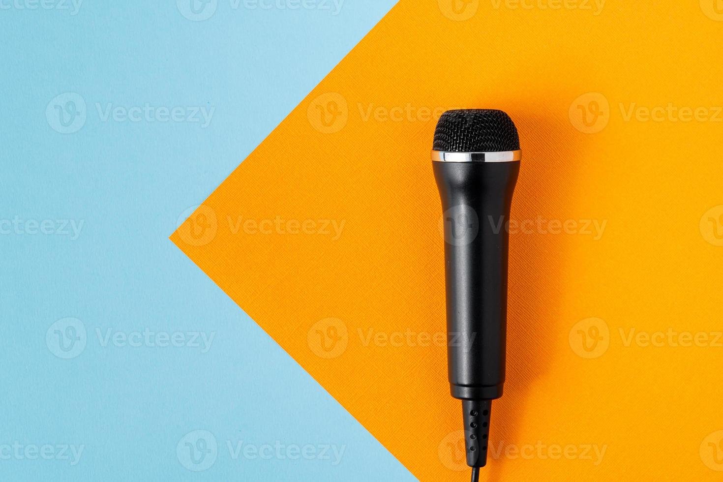 Cable microphone on colorful turquoise and orange background design, overhead, copy space photo