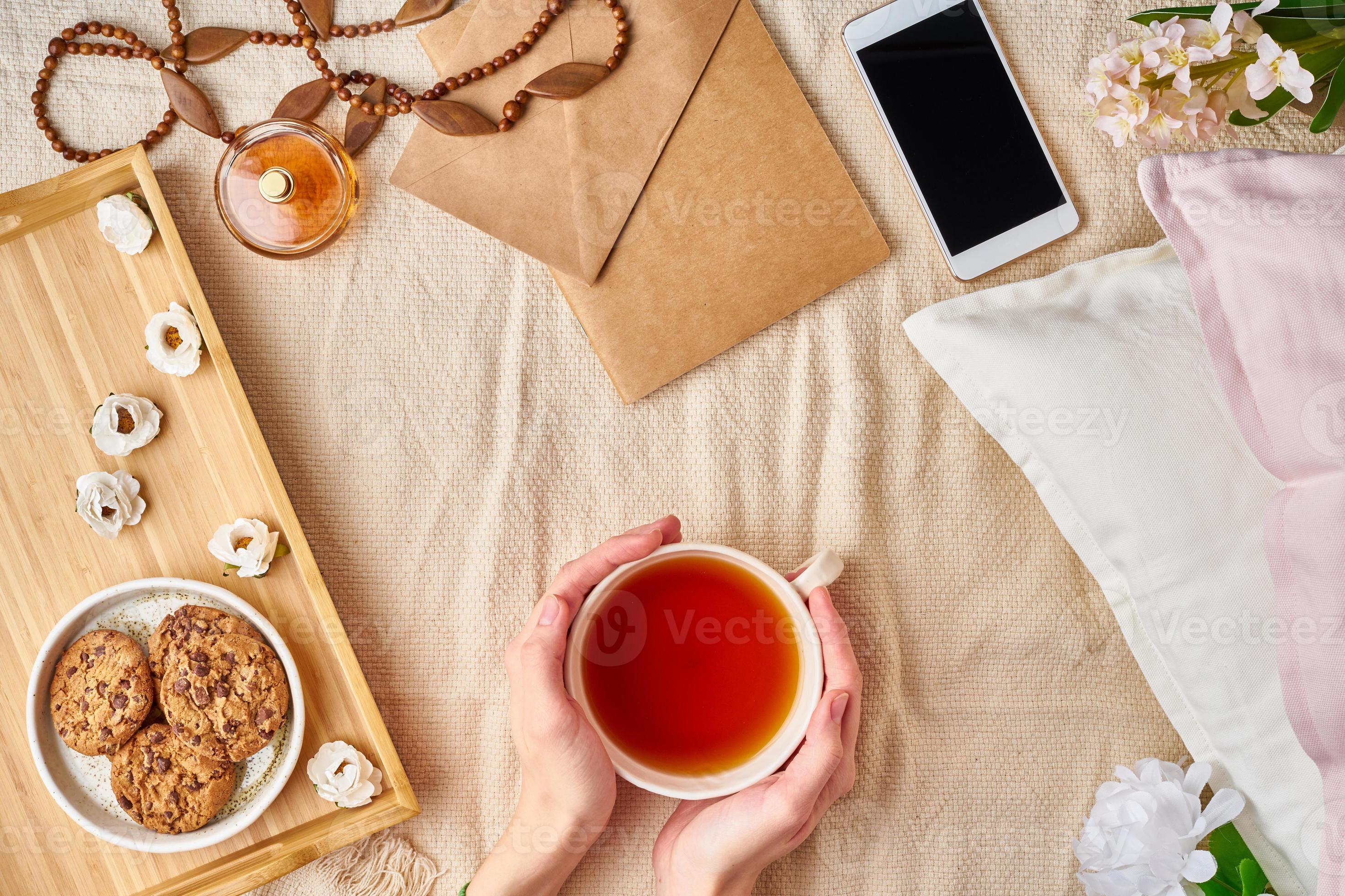 Woman holding mug of hot tea. Lazy cozy morning in bed. Flat lay woman  accessories with letter, envelope, smartphone, perfume. 7463386 Stock Photo  at Vecteezy