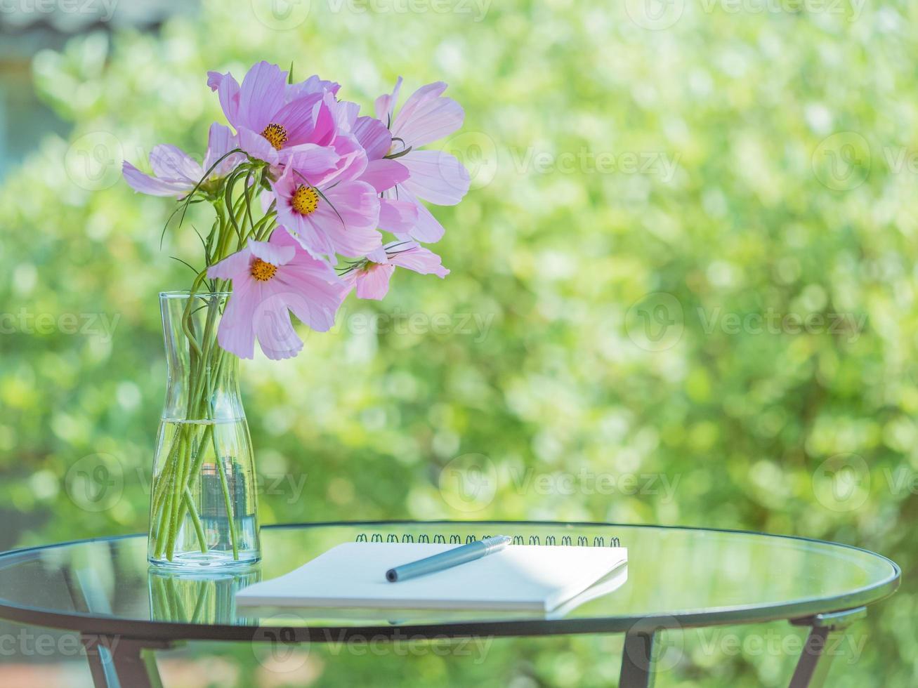 Notebook, pen on table in Park garden, bouquet of flowers, empty space. Concept for thinking photo